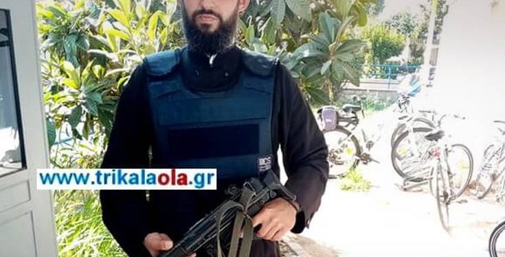 Ο αστυνομικός-ιερέας με το αλεξίσφαιρο και το όπλο σε αστυνομικό τμήμα στα Τρίκαλα